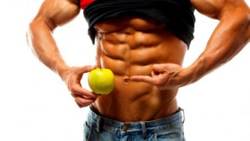 a shredded bodybuilder holding a green apple