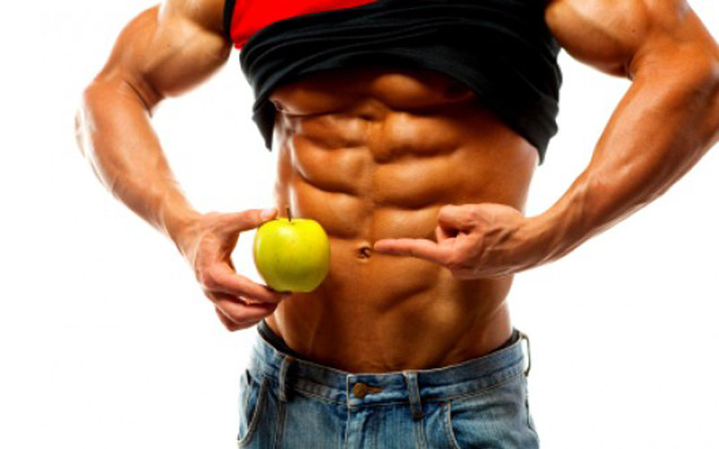 a shredded bodybuilder holding a green apple