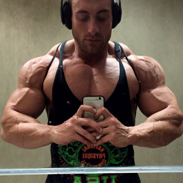 a buff bodybuilder taking a bathroom selfie