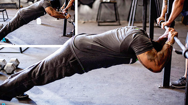 a man performing bodyweight tricep extensions during a workout without weights