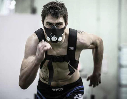 a man using an altitude mask while performing cardio for a spiderman workout