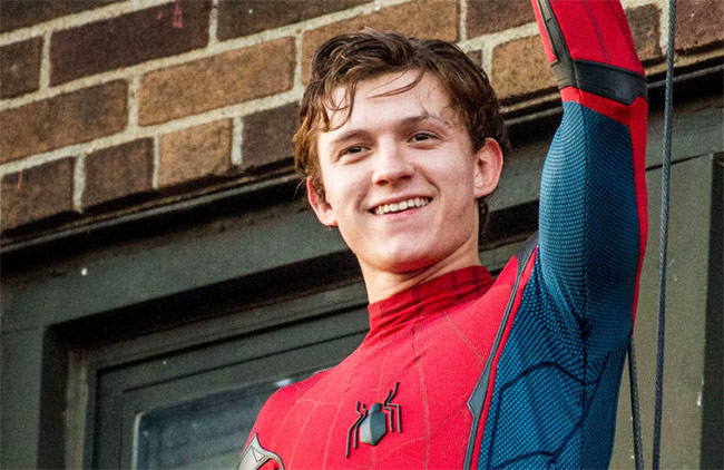Tom holland in his spiderman outfit waving during his workout
