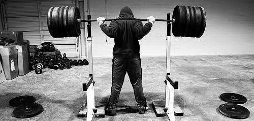 man standing with barbell on his back