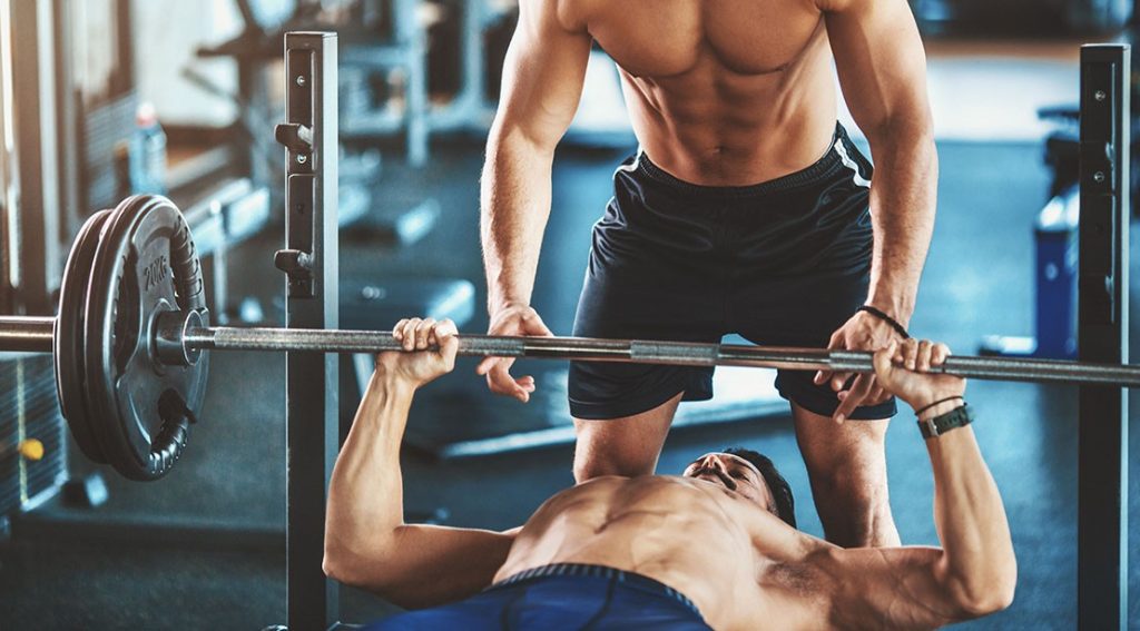 guy bench pressing with spotter