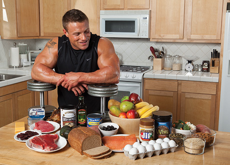 a bodybuilder looking at his food in the kitchen