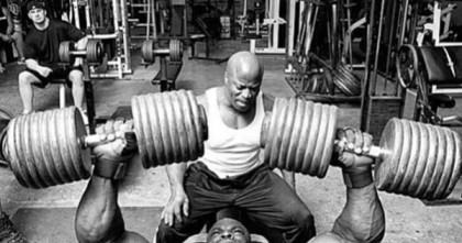 a bodybuilder doing heavy dumbbell presses