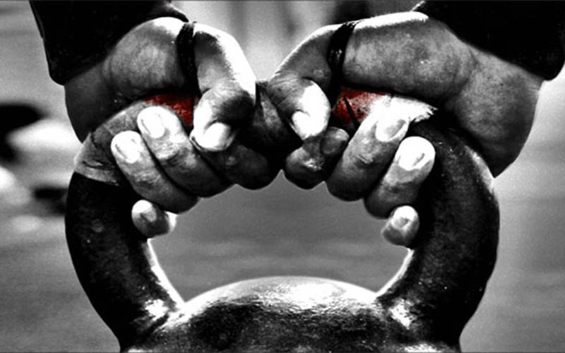 a person gripping onto a kettlebell handle