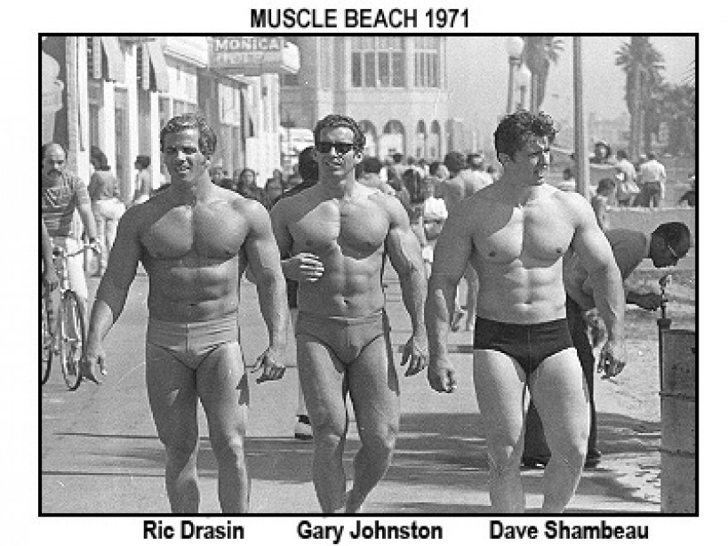 three bodybuilders walking down muscle beach in the 70s