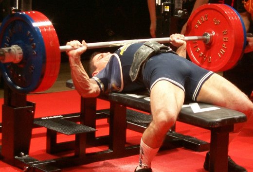 a powerlifter performing the bench press at a meet
