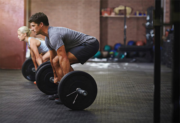 Couple deadlifting together in a workout guide for building lean mass