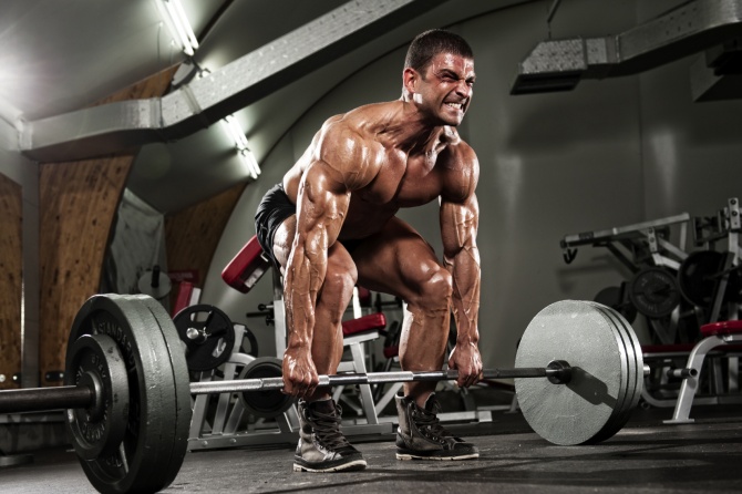 Bodybuilder lifts a heavy deadlift fueled by pre workout with caffeine