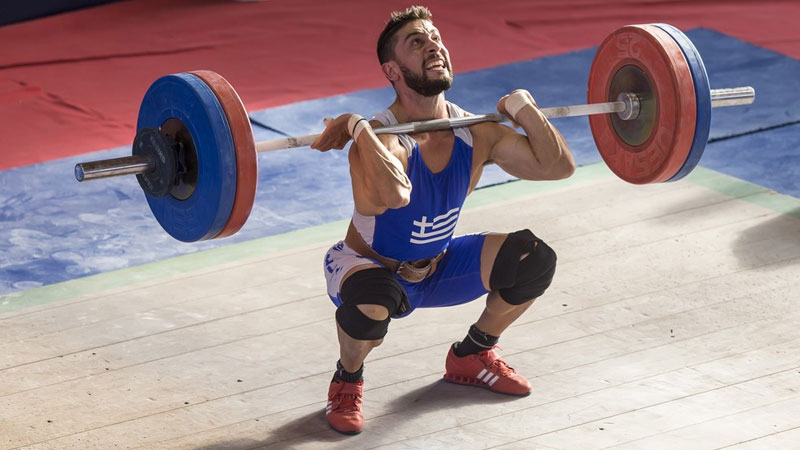 Male athlete using a barbell to get stronger and faster