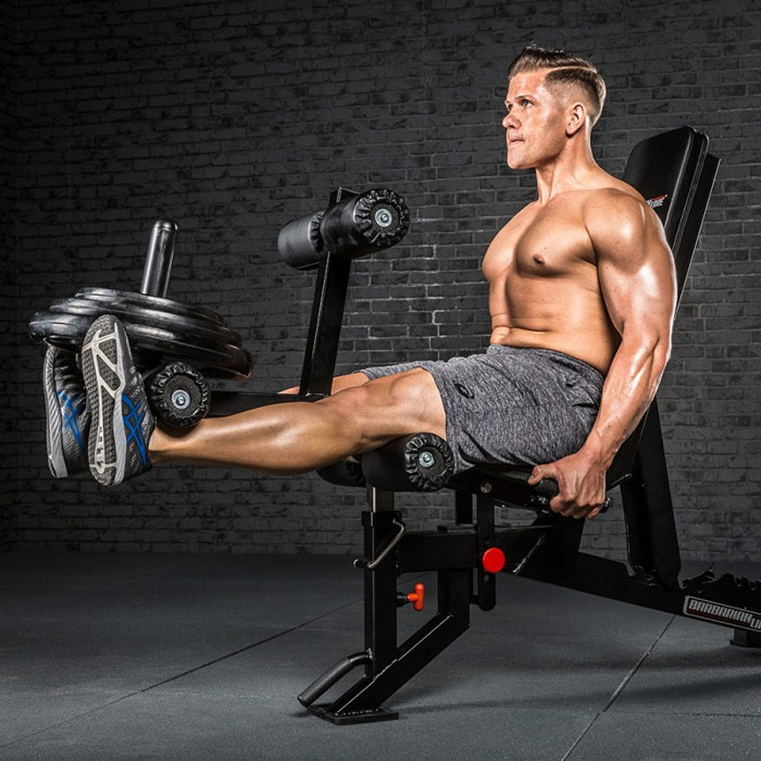 man performs leg extension on leg extension machine