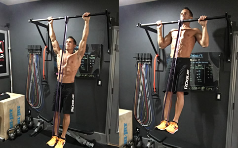 Male athlete performing banded pull-ups in the gym