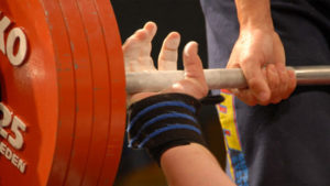 hand takes grip on barbell for bench press