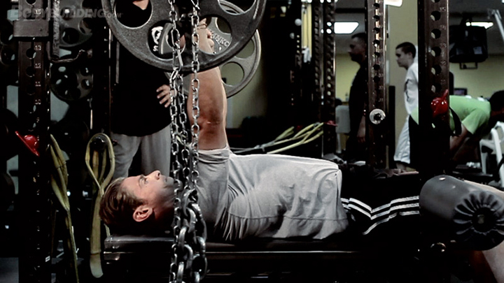 Strength athlete using accommodating resistance to increase weight workout intensity