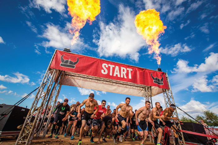 Obstacle course racers run from start line