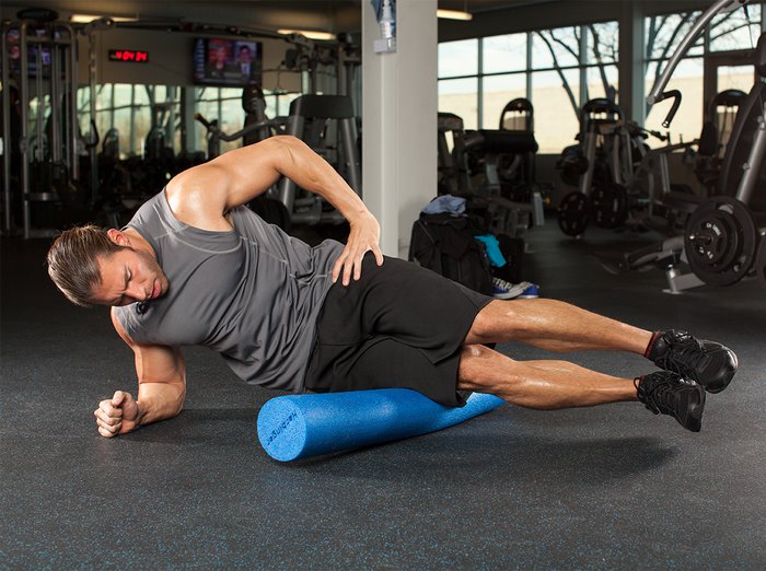 bodybuilder foam rolls the IT band