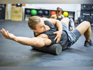 bodybuilder foam rolls his lats