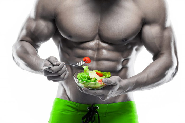 bodybuilder eats a bowl of salad