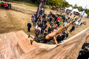 man runs up quarter pipe during obstacle course race