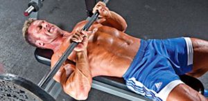 bodybuilder performs close grip bench press for arms workout