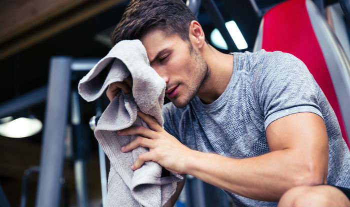 bodybuilder wiping sweat away