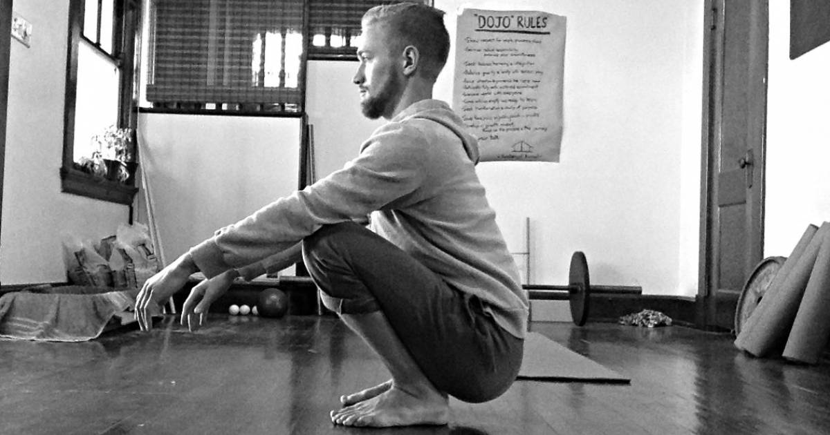 man performs deep resting third world squat