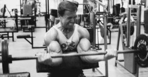 Iconic bodybuilder Larry Scott performing preacher curl