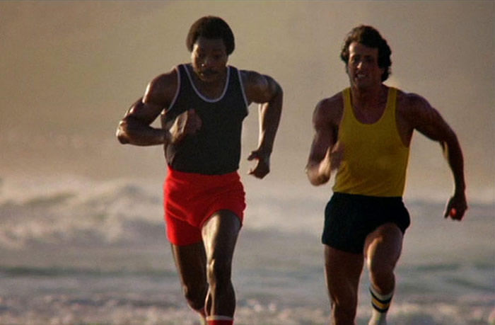 Rocky and Apollo Creed sprinting on a beach