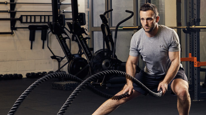 man working out with battle ropes