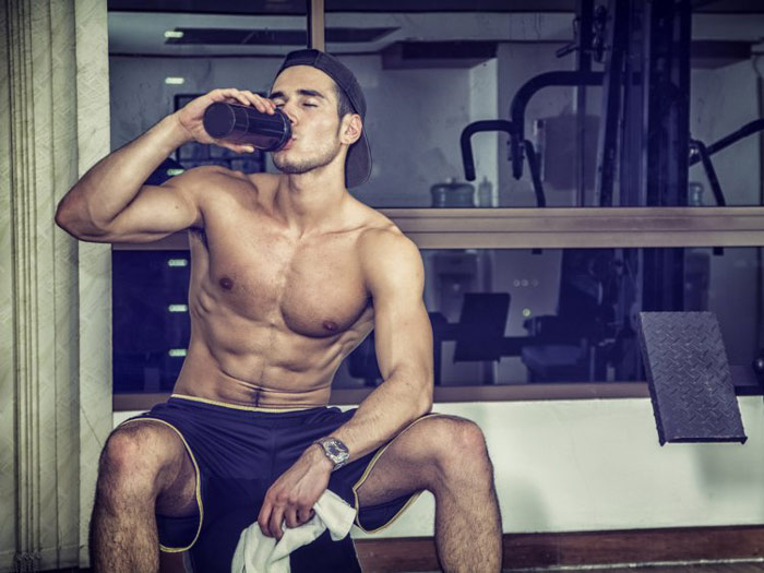 fit and healthy man drinking pre workout drink