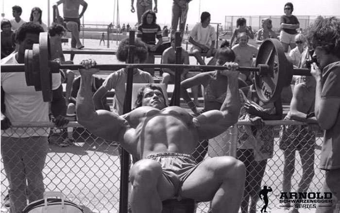 Arnold Schwarzenegger performing incline bench press to develop upper chest