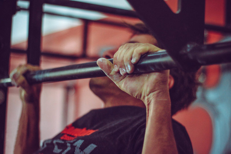 athlete performing pull up as compound exercise