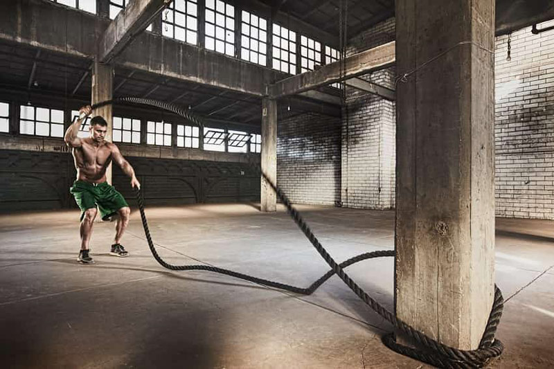 athlete using battle ropes for fat loss