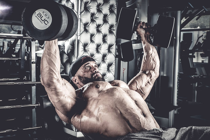 bodybuilder performing incline dumbbell press