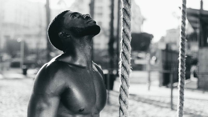 Fit, healthy, and muscular man looking up at a rope