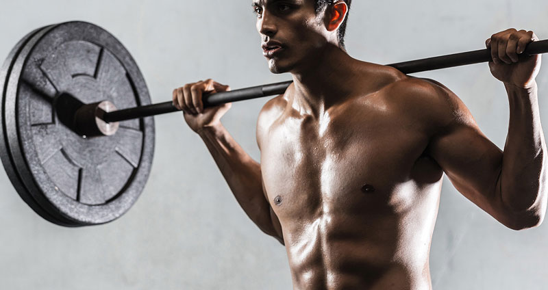 bodybuilder performing barbell back squat as muscle building exercise