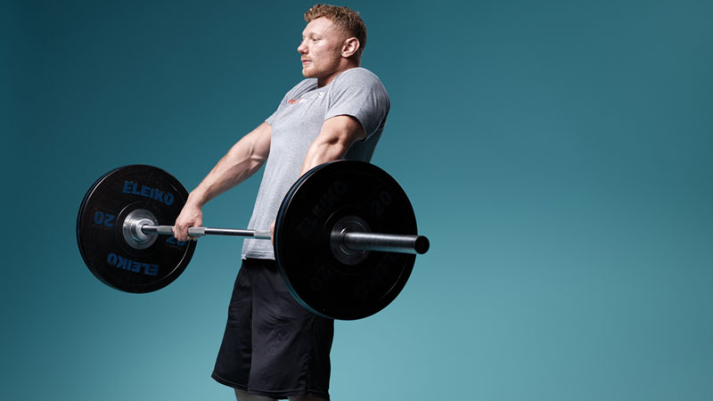 muscular man performing power clean as part of HIIT workout