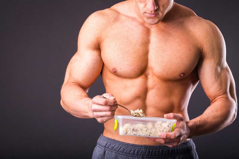 bodybuilder eating brown rice as part of lean bulking nutrition plan