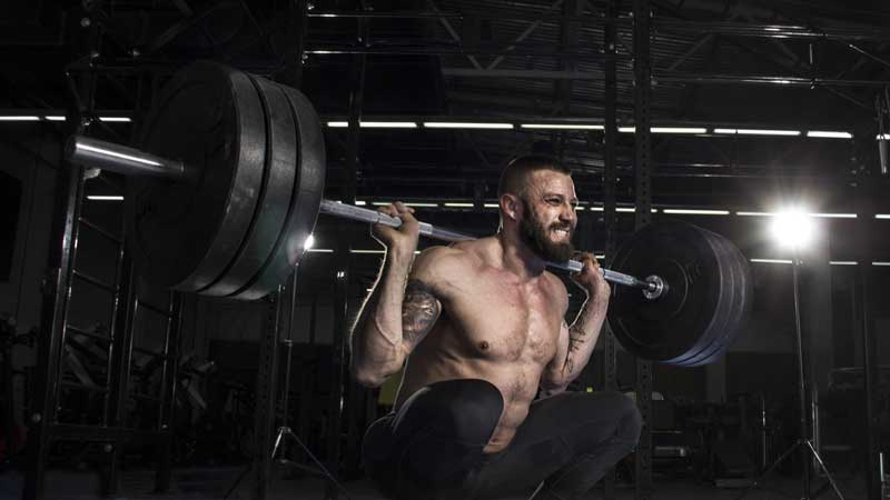 bodybuilder using back squat to build lean muscle as part of lean bulk