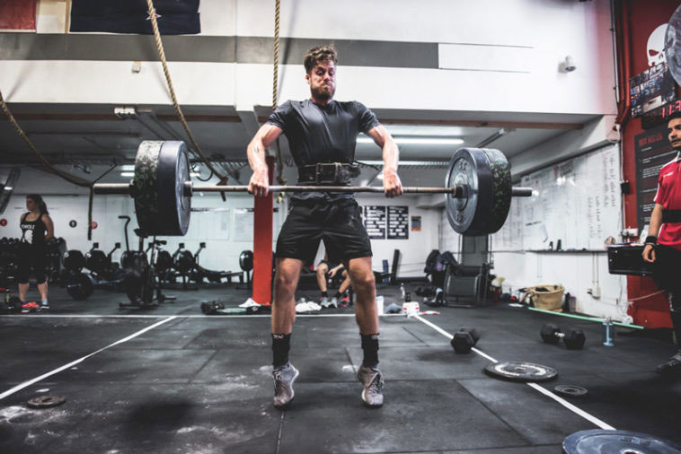 muscular athlete performing power clean