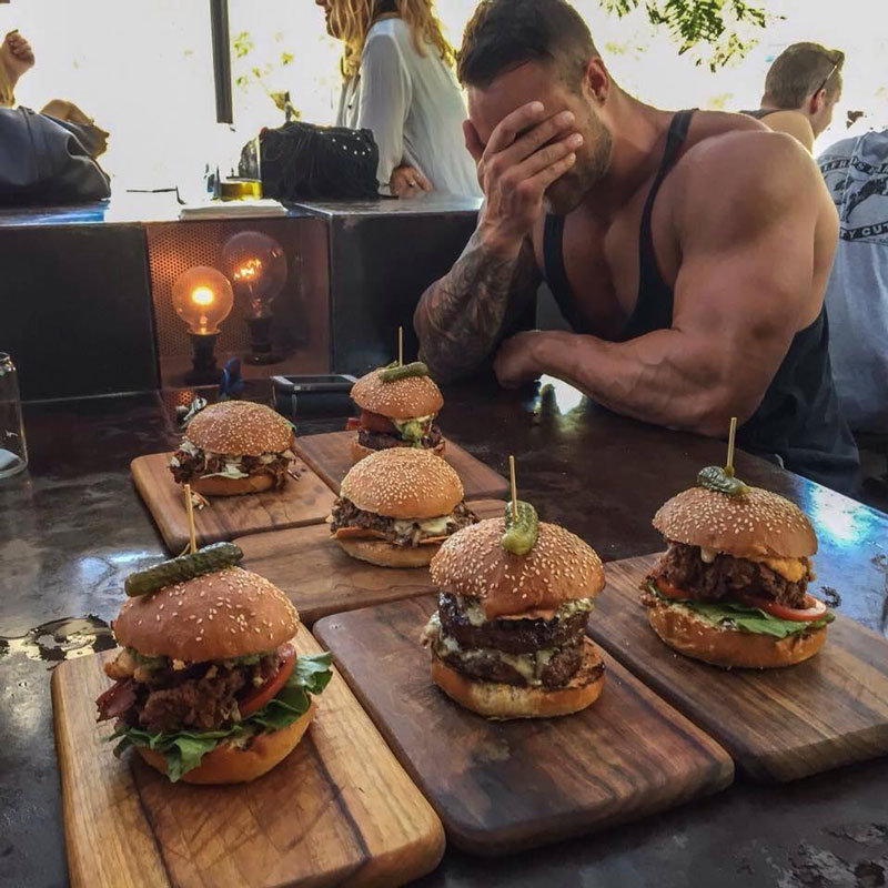 Bodybuilder about to enjoy treat meal of five beef burgers