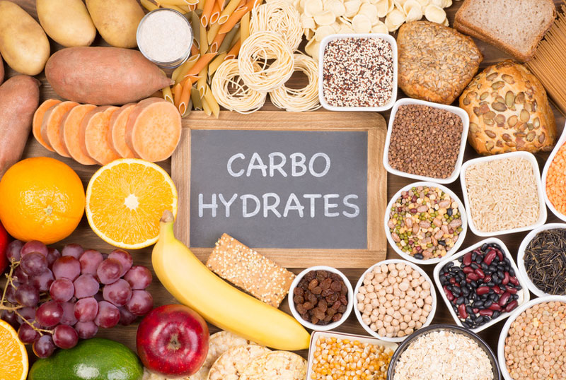 Collection of carbohydrate foods including sweet potato, bananas, and grains