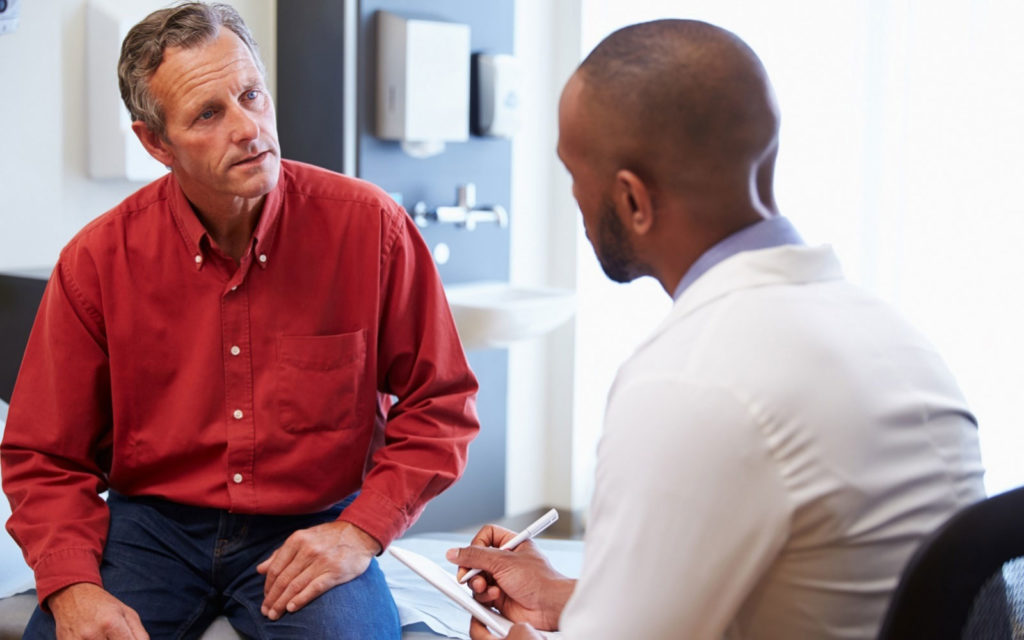 Older man speaking to doctor about the causes of low testosterone