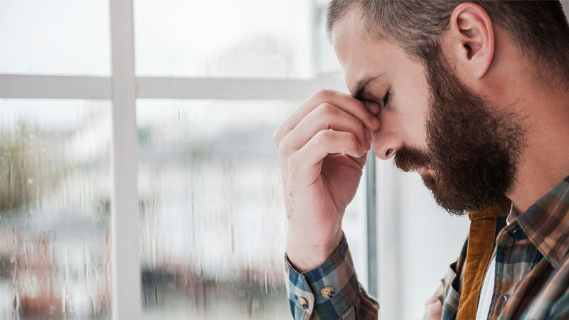 Depressed man pondering low testosterone impact on his health