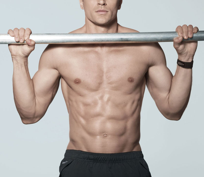 shirtless man with ripped physique holding pull up bar