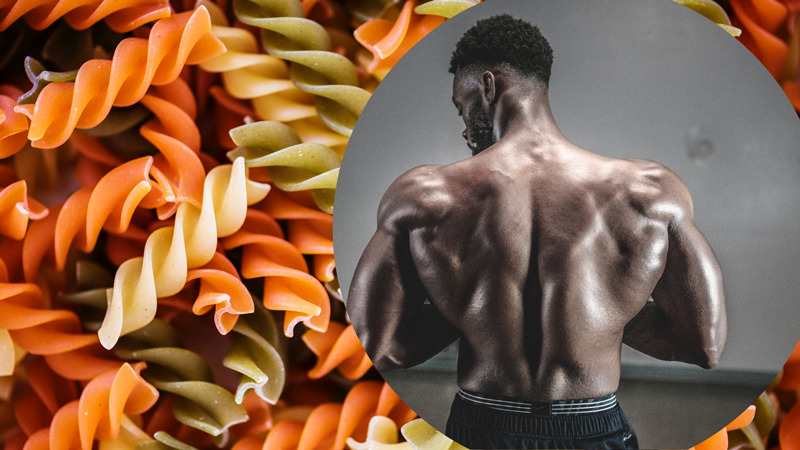 Pasta as background behind muscular athlete to show important carbs for muscle building