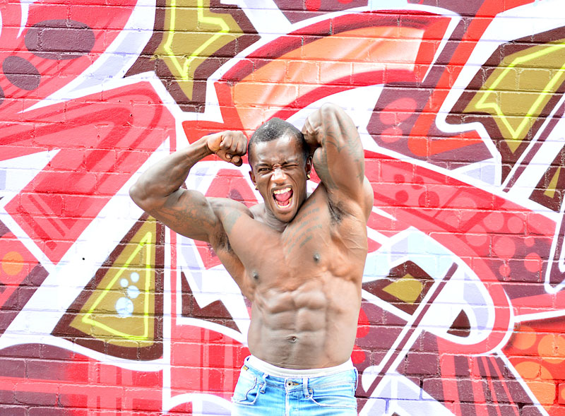 Bodybuilder posing in front of red wall