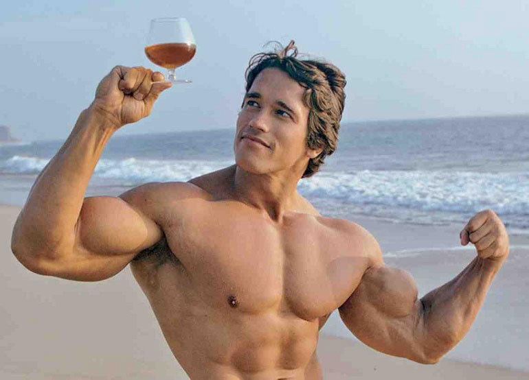 Famous bodybuilder Arnold Schwarzenegger holding glass of alcohol